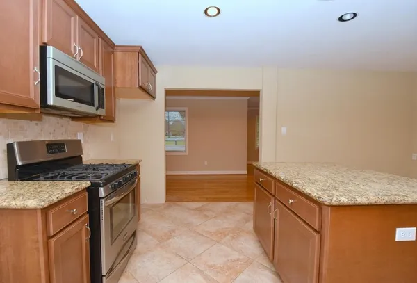 a kitchen with stainless steel appliances granite countertop a stove and a microwave