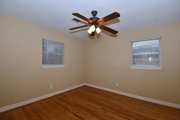 a view of room with wooden floor and fan