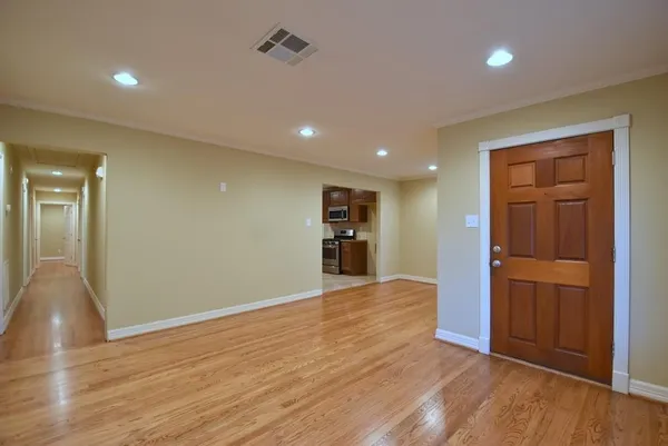a view of empty room with wooden floor