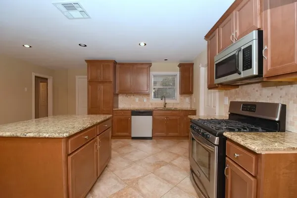 a kitchen with stainless steel appliances granite countertop a sink stove and microwave