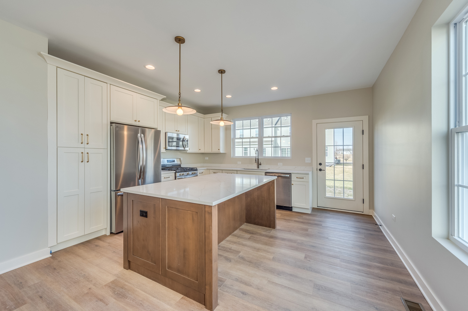 1076 Freedom Road Elburn, IL 60119 - Photo 10 of 31 a large kitchen with a center island wooden floor and stainless steel appliances