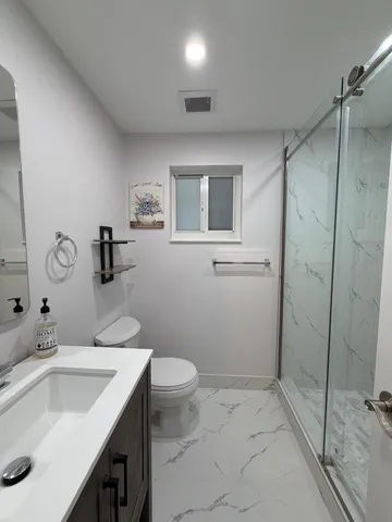 a bathroom with a sink toilet and shower
