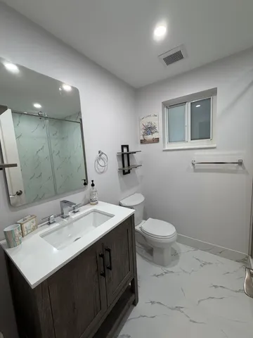 a bathroom with a sink toilet and mirror