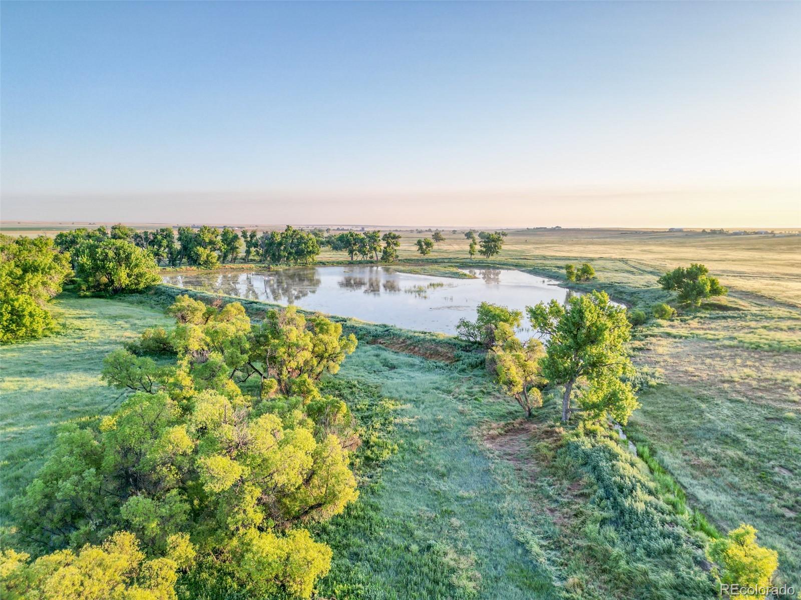 Pass Me By Road Strasburg, CO 80136 - Photo 26 of 46 a view of lake with houses in the back