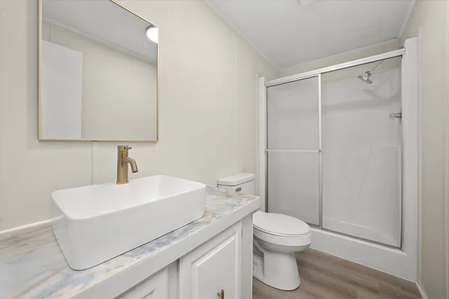 a bathroom with a sink a toilet and shower