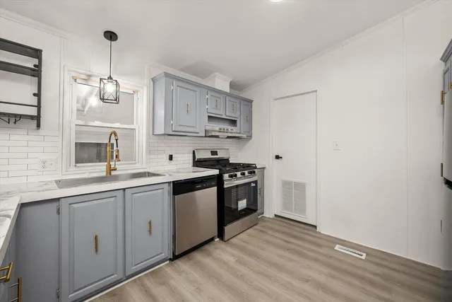 a kitchen with stainless steel appliances granite countertop a sink stove and refrigerator