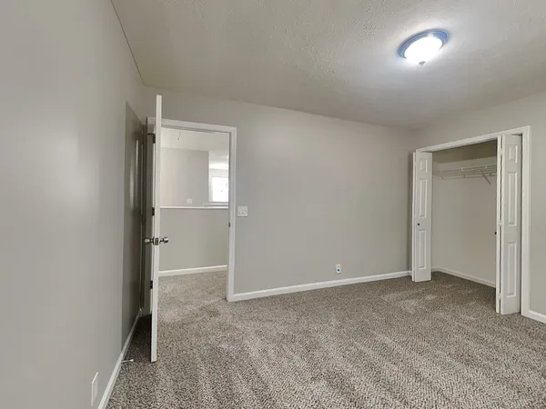 an empty room with closet and mirror