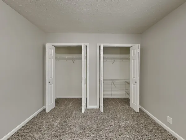 an empty room with closet and a bathroom