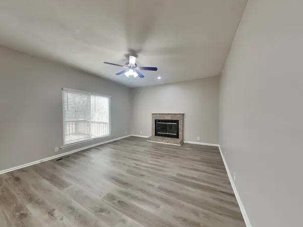 a view of an empty room with a fireplace and a window