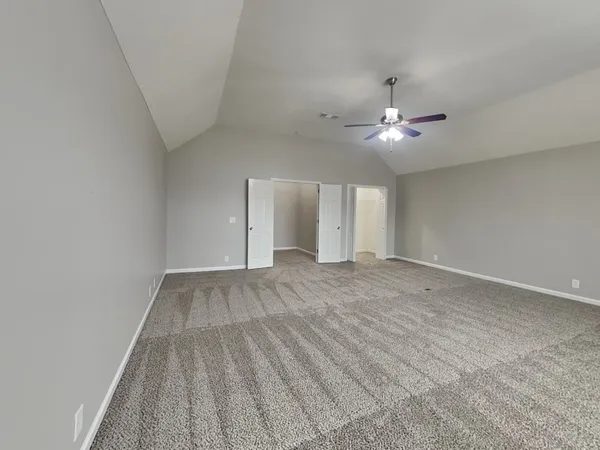 a view of an empty room with a ceiling fan