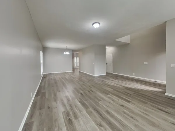 a view of an empty room and wooden floor