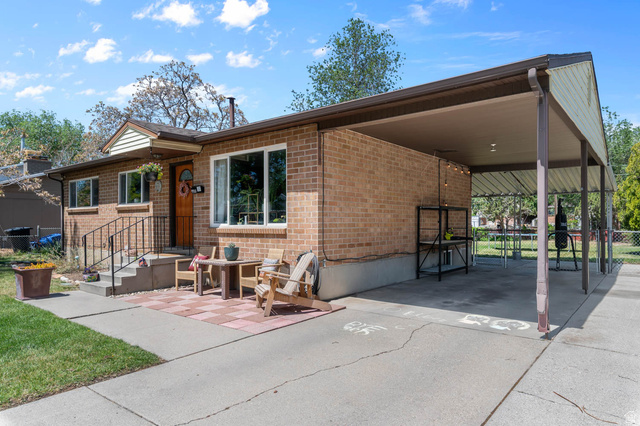 9902 South Poppy Lane Sandy, UT 84094 - Photo 3 of 25 Brick exterior featuring a covered carport, concrete driveway, and a front patio with paver accents