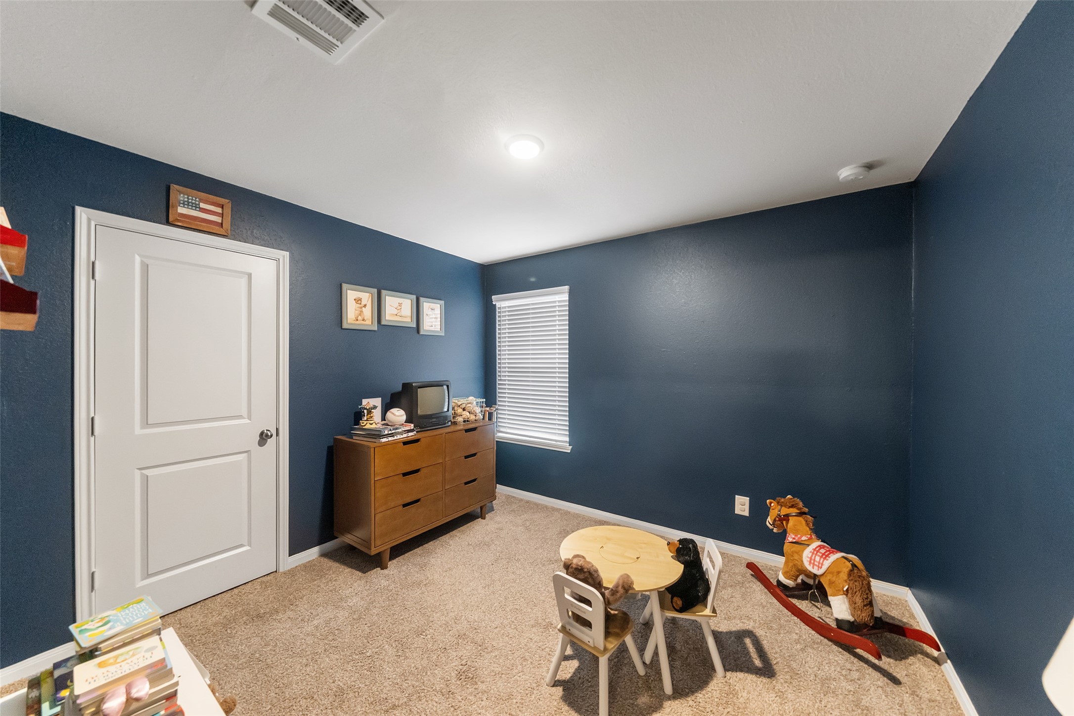 26431 Pin Oak Drive Hempstead, TX 77445 - Photo 20 of 32 Spacious secondary bedroom with plush carpet, modern paint tones, and great wall space for flexible furniture layouts. Natural light and 2" blinds create a comfortable, finished look.