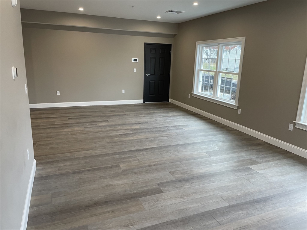 1 Brattle Street, Unit 1 Worcester, MA 01606 - Photo 10 of 21 an empty room with wooden floor and windows