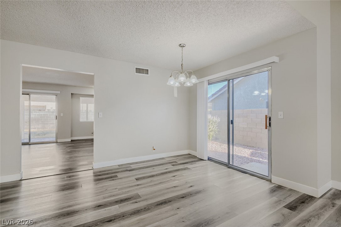 2343 Valleywood Road Henderson, NV 89014 - Photo 18 of 29 Sliding glass doors open to a private outdoor space, complementing the wood-style flooring.
