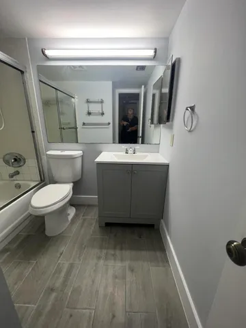a bathroom with a sink mirror vanity and toilet