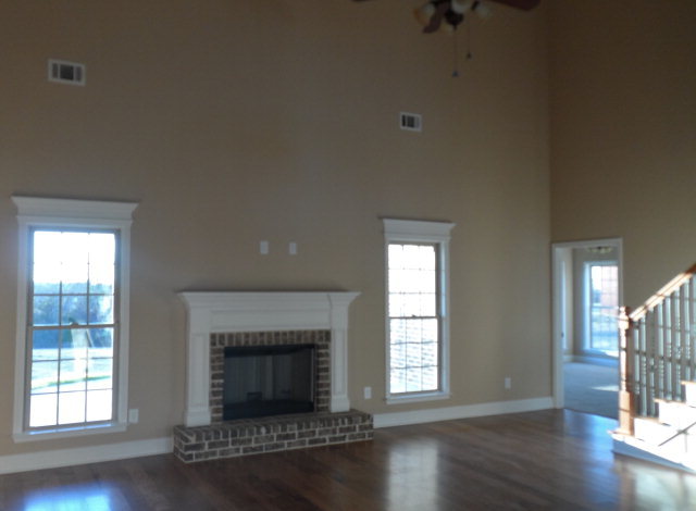 346 Eagle Ridge Road Macon, GA 31216 - Photo 8 of 30 an empty room with wooden floor fireplace and windows