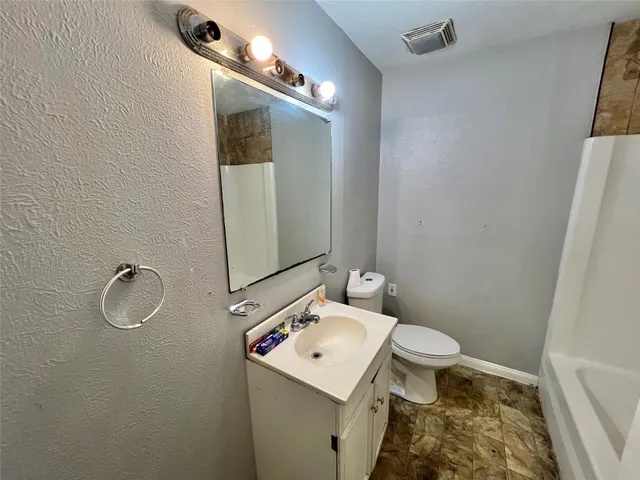 a bathroom with a sink toilet and mirror