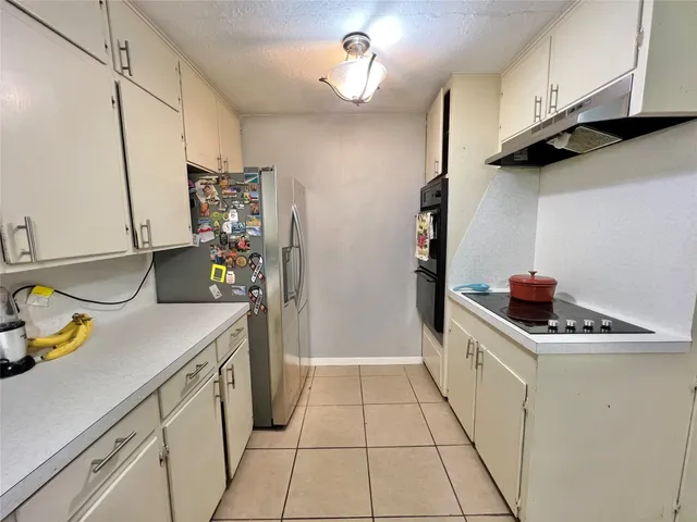 a kitchen with stainless steel appliances a sink a stove a refrigerator and cabinets