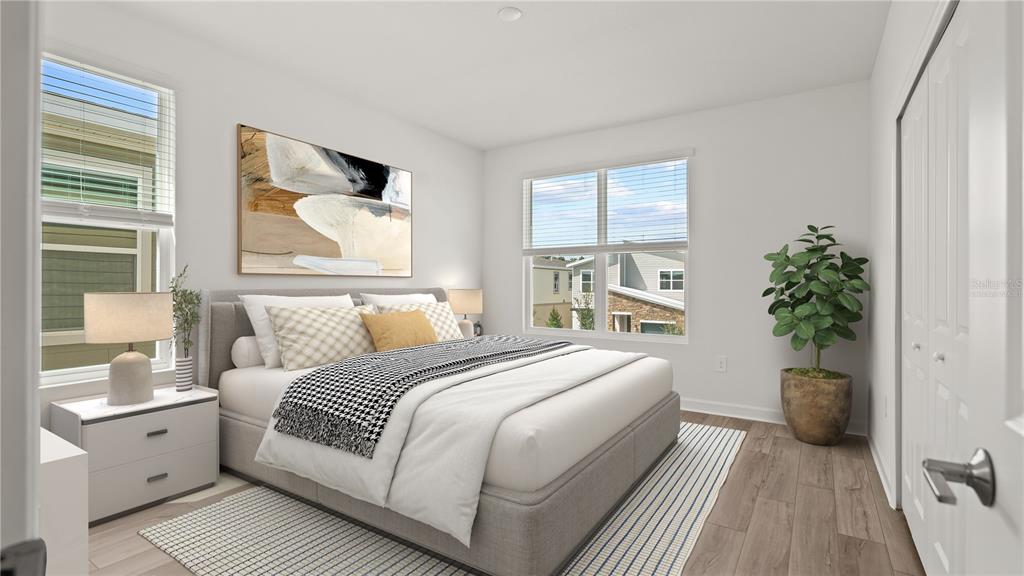 7851 Poplin Street Kissimmee, FL 34747 - Photo 15 of 36 a bedroom with a large bed and a potted plant