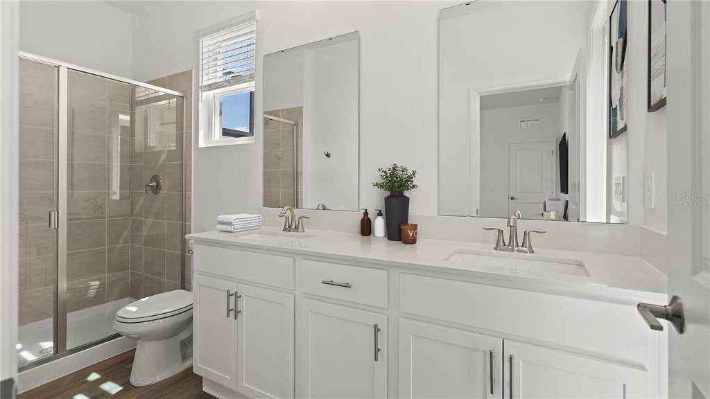 7851 Poplin Street Kissimmee, FL 34747 - Photo 17 of 36 a bathroom with a double vanity sink toilet and shower