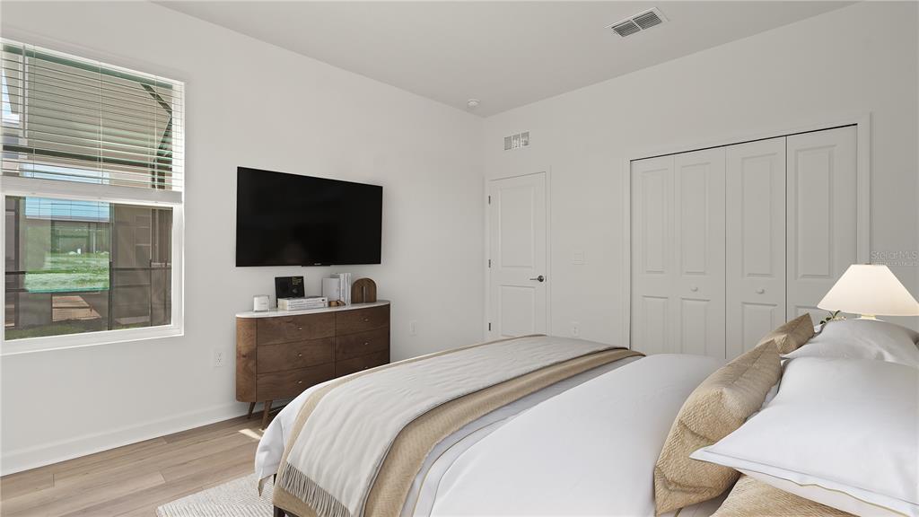 7851 Poplin Street Kissimmee, FL 34747 - Photo 20 of 36 a bedroom with a bed and a flat tv screen on wall