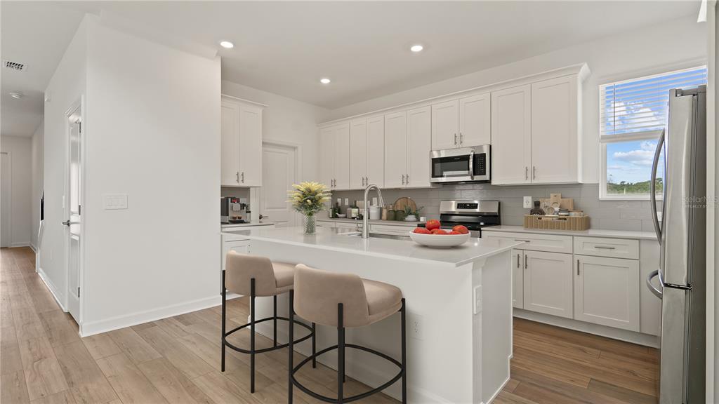 7851 Poplin Street Kissimmee, FL 34747 - Photo 3 of 36 a kitchen with stainless steel appliances granite countertop a refrigerator stove microwave and sink