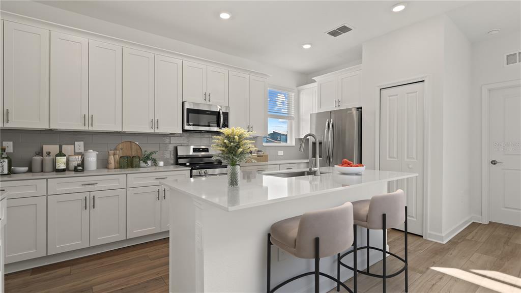 7851 Poplin Street Kissimmee, FL 34747 - Photo 4 of 36 a kitchen with appliances a sink and cabinets