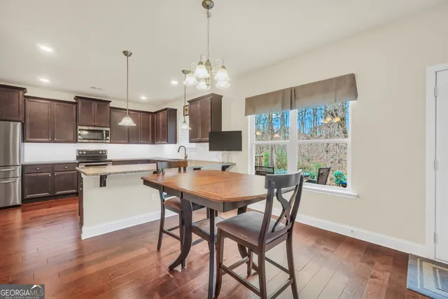 a kitchen with kitchen island granite countertop a sink a counter space appliances and cabinets