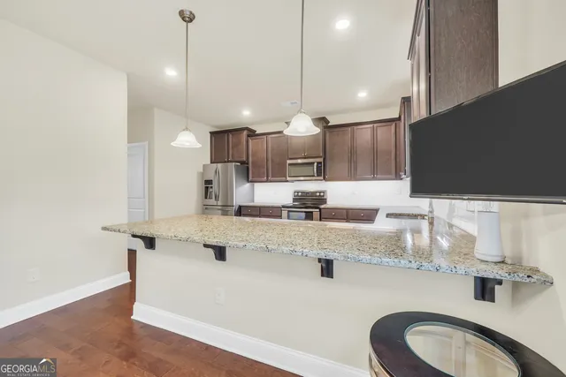 a kitchen with stainless steel appliances granite countertop wooden cabinets a sink and dishwasher