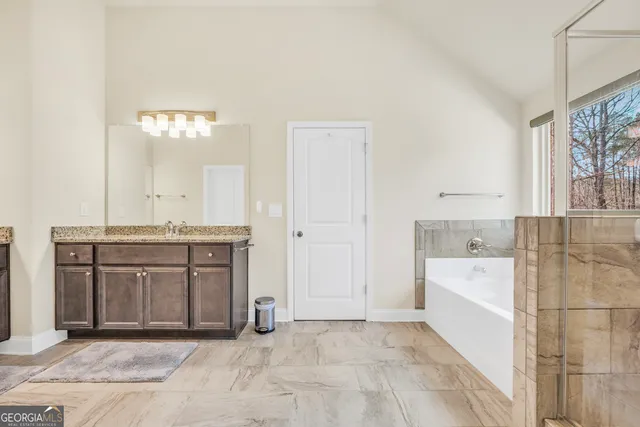 a bathroom with a granite countertop sink a toilet and shower