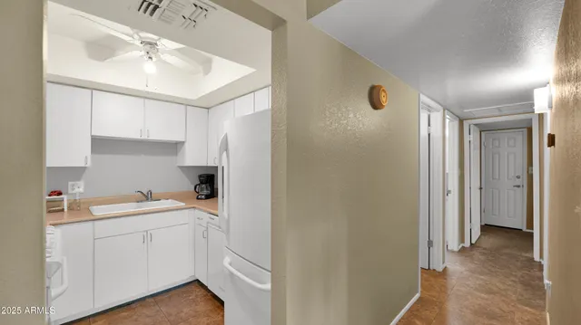 a view of a kitchen with white cabinets and wooden floor