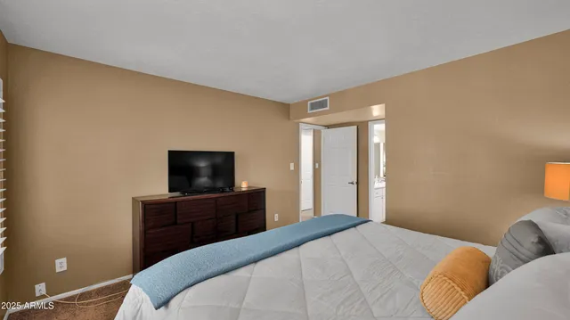 a bedroom with a bed and a flat screen tv