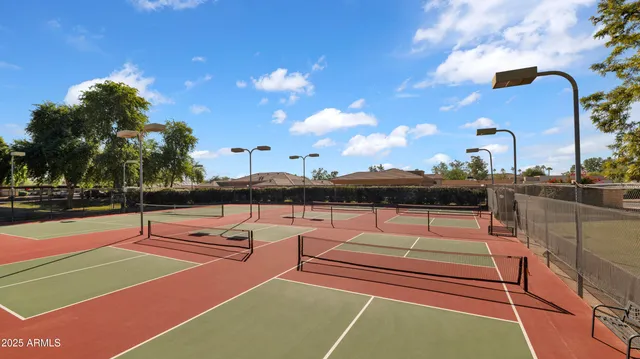 a view of a tennis ground with large trees