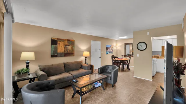 a living room with furniture a clock on wall and a table