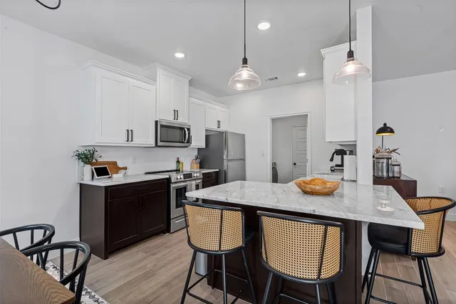 a kitchen with a dining table chairs and microwave