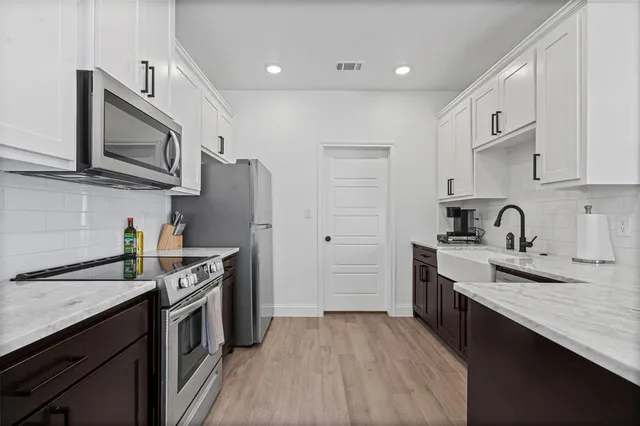 a kitchen with stainless steel appliances granite countertop a sink stove and refrigerator