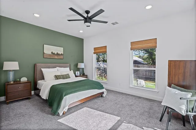 a bedroom with a bed a dresser and next to a window