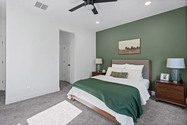 a bedroom with a bed and a painting on the wall