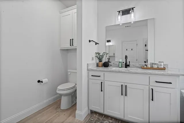 a bathroom with a toilet sink and mirror