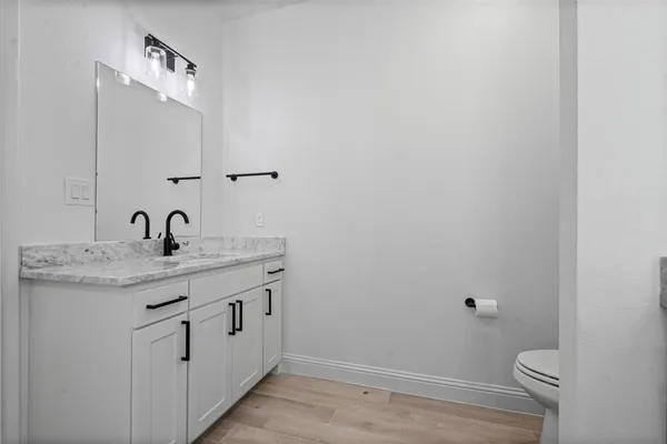 a bathroom with a granite countertop sink a toilet and a mirror