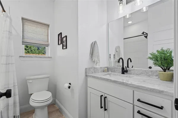 a bathroom with a granite countertop toilet sink and mirror