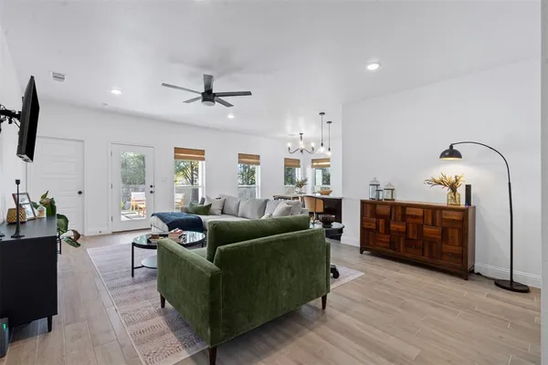 a living room with furniture a ceiling fan and a window