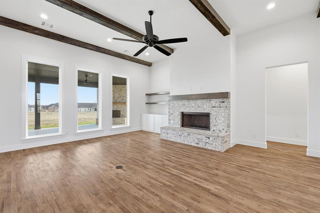 6412 Rigel Road Godley, TX 76044 - Photo 10 of 38 a view of an empty room with wooden floor fireplace and a window