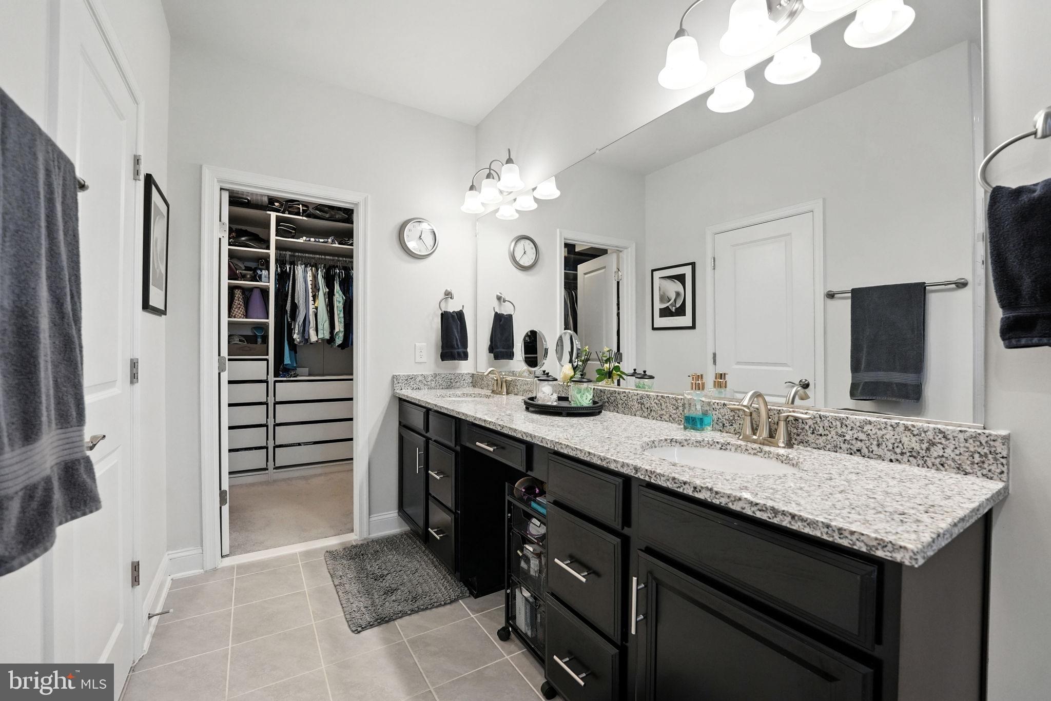 17233 Branched Oak Road Dumfries, VA 22026 - Photo 29 of 79 a bathroom with a granite countertop sink a large mirror and a shower