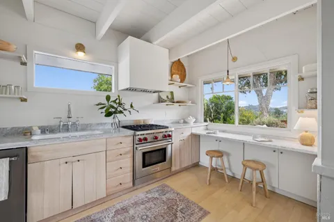 a kitchen with a sink stove and white cabinets