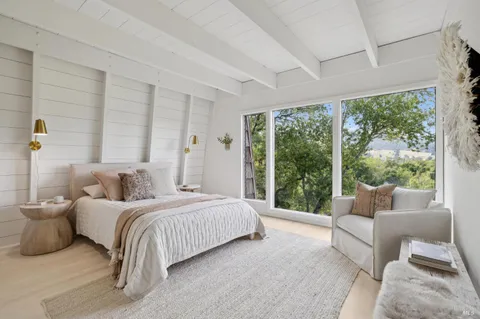 a bedroom with a bed and a large window