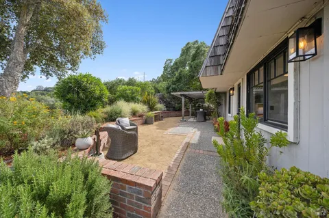 a view of a patio with table and chairs and potted plants