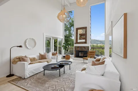 a living room with furniture a fireplace and a chandelier
