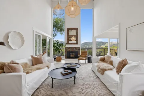 a living room with furniture fireplace and a large window